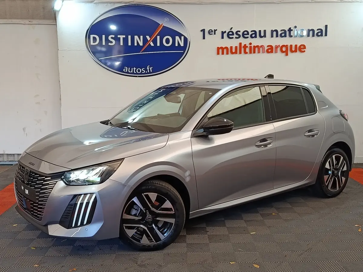 Peugeot 208 gris clair vue 3/4 avant droit, avec phares LED et jantes alliage distinctives.