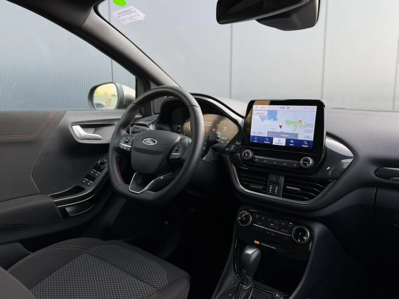 Vue intérieure côté conducteur du Ford Puma gris magnétique 2024, avec tableau de bord numérique et écran tactile GPS.