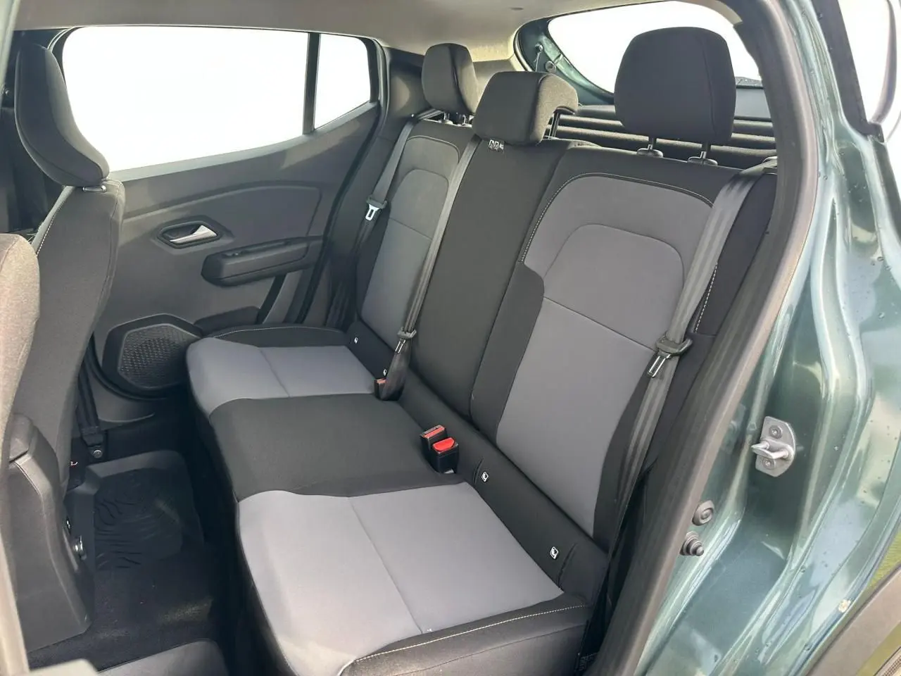 Vue intérieure côté droit sur la banquette arrière gris clair et noir de la Dacia Sandero III Stepway Vert Cèdre 2025.