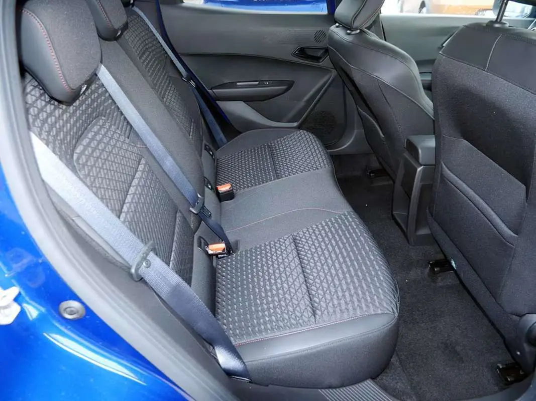 Vue intérieure côté gauche de la banquette arrière en tissu noir avec surpiqûres rouges d’une Renault Clio VI Bleu Iron.