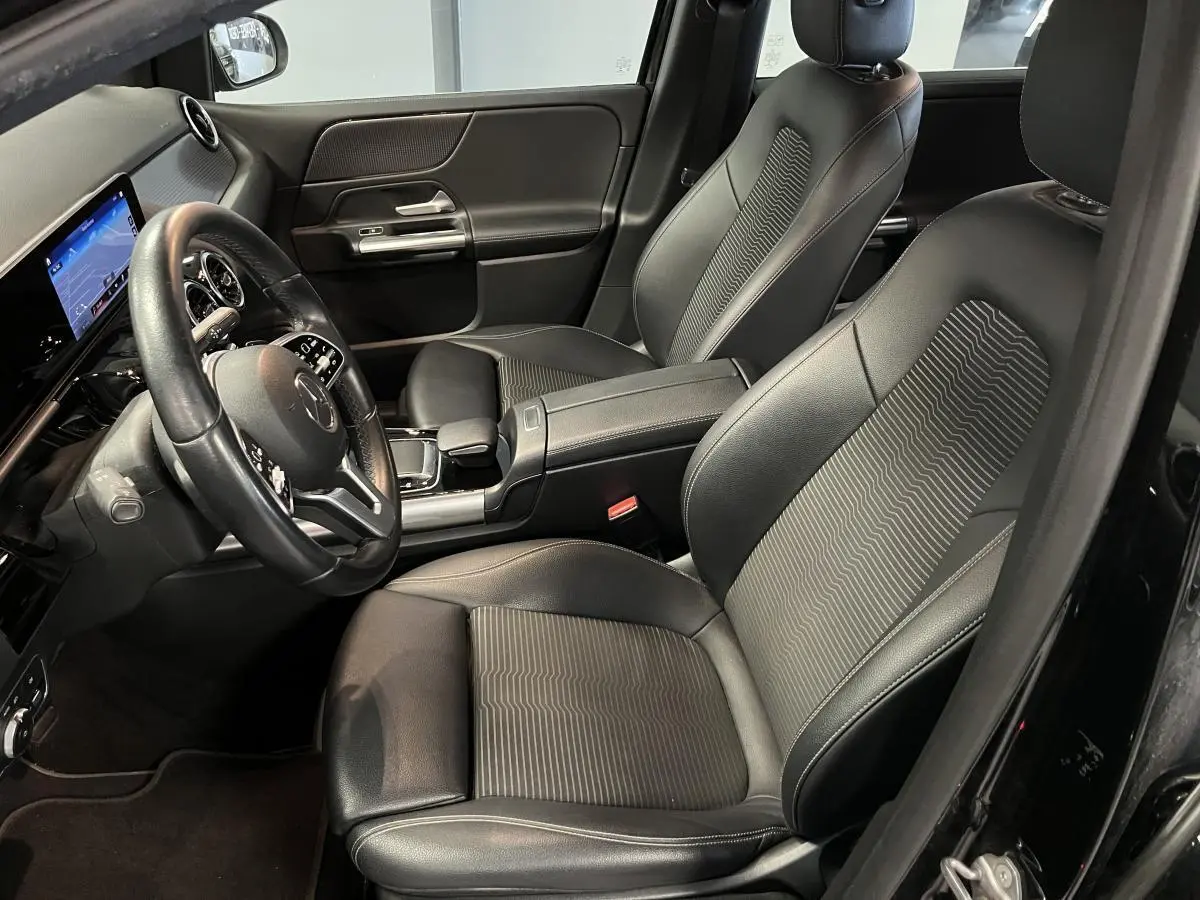 Intérieur noir de la Mercedes Classe B 180 d 2019, vue côté conducteur avec sièges en similicuir et tableau de bord digital.