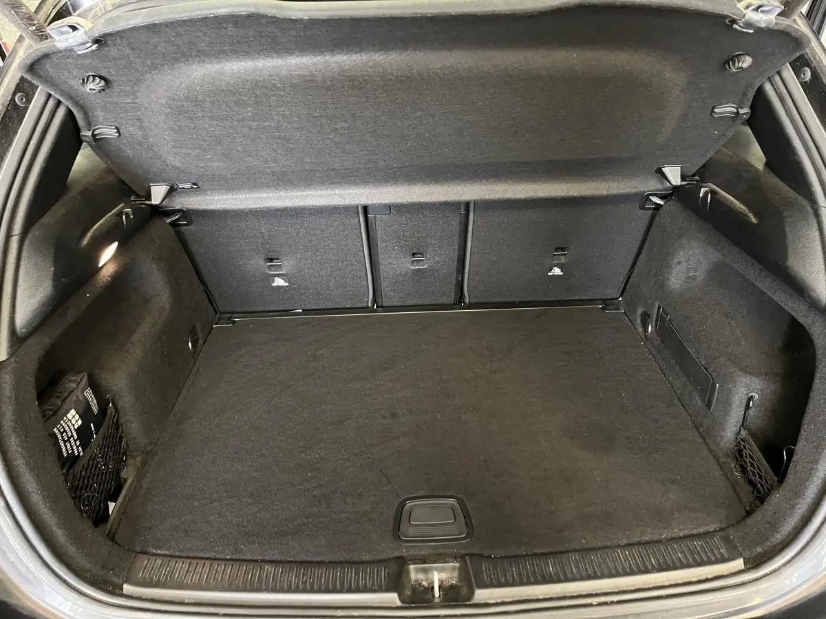 Coffre ouvert noir du Mercedes Classe B 180 d 2019, vue intérieure arrière montrant le plancher et les rangements latéraux.