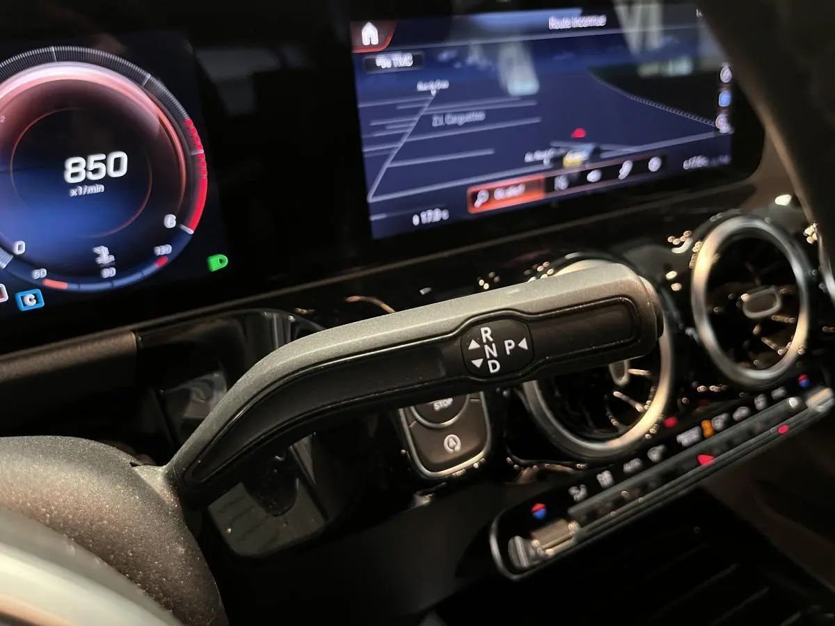 Gros plan sur la commande de boîte automatique noire et l'instrumentation digitale de la Mercedes Classe B 180 d 2019.