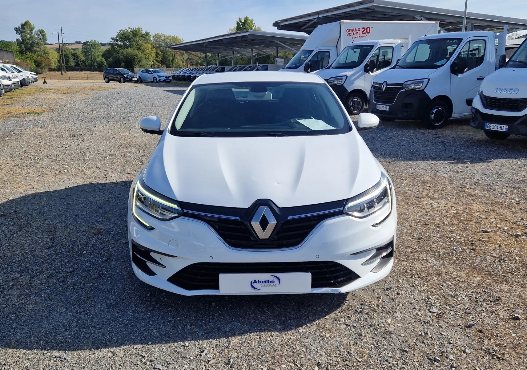 Vue avant d'une Renault Mégane 1.5 Blue dCi blanche 2022 avec feux LED et calandre noire brillante.