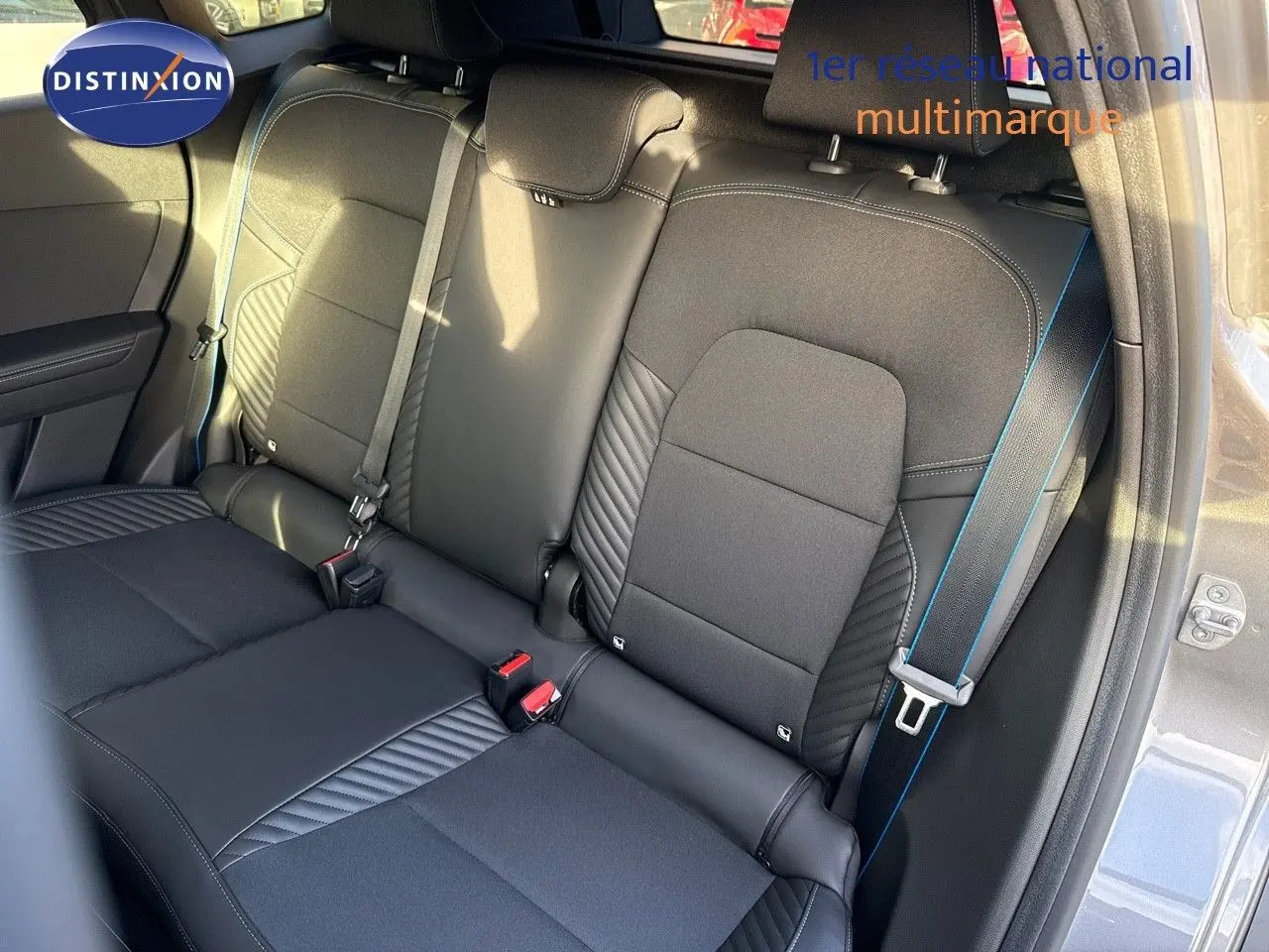 Vue du siège arrière droit en tissu noir avec surpiqûres bleues du Renault Symbioz gris Cassiope 2024 E-Tech 145 Esprit Alpine.