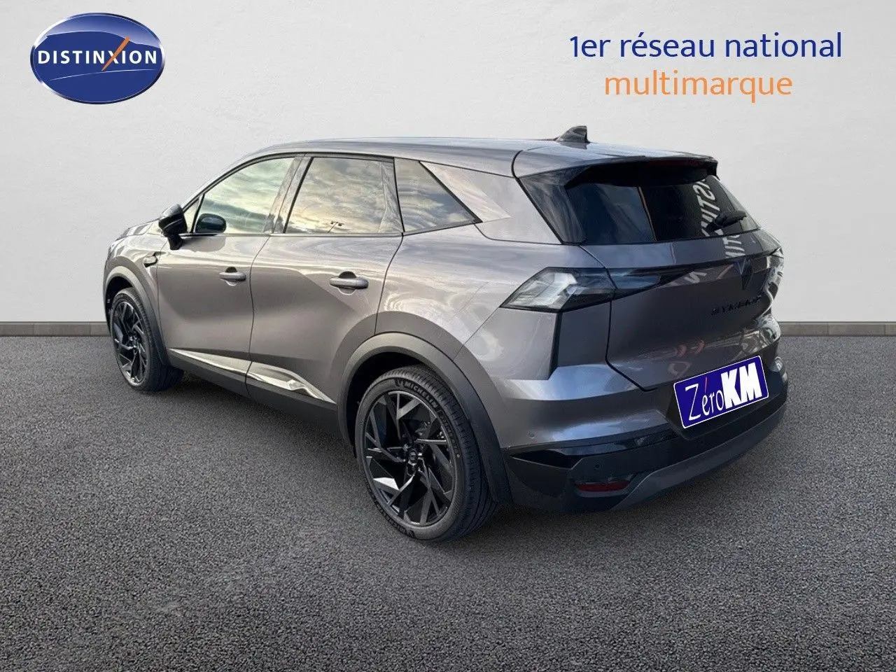 Vue 3/4 arrière droite du Renault SYMBIOZ 2024 gris Cassiope avec jantes noires et hayon électrique visible.
