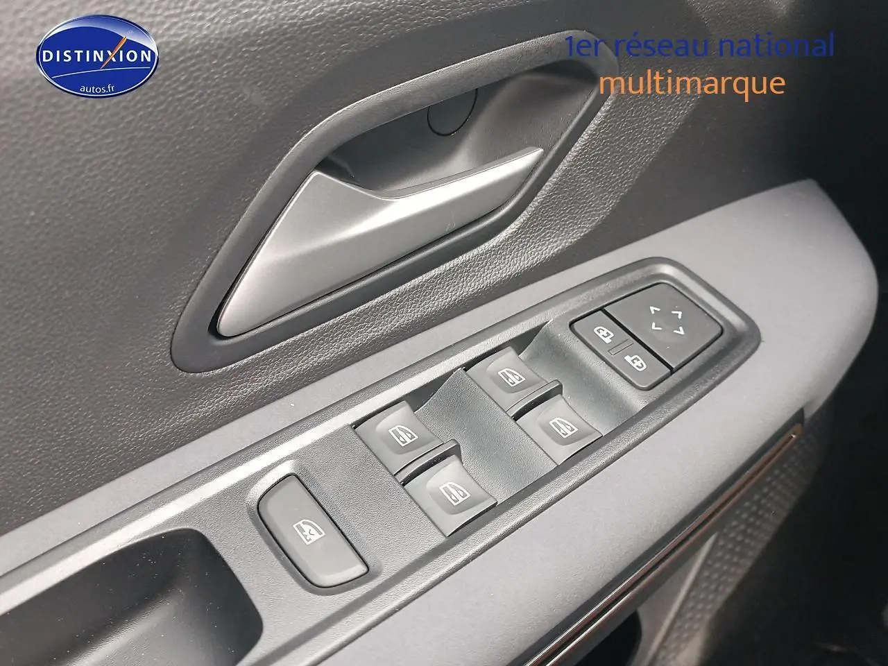 Gros plan sur la commande des vitres électriques côté conducteur de la Dacia Sandero noire 2025.