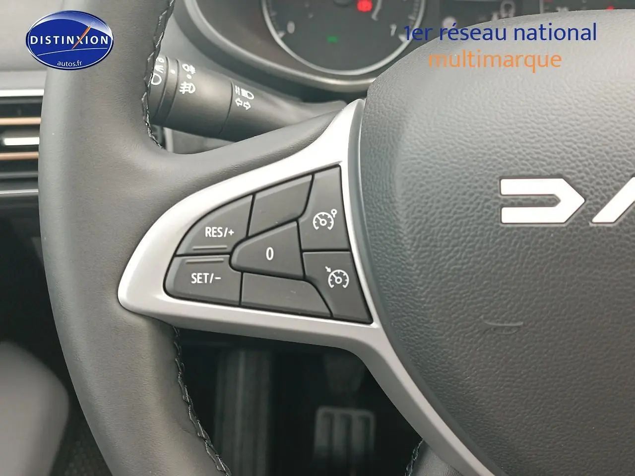 Gros plan sur les commandes de régulateur de vitesse à gauche du volant noir de la Dacia Sandero 2025.