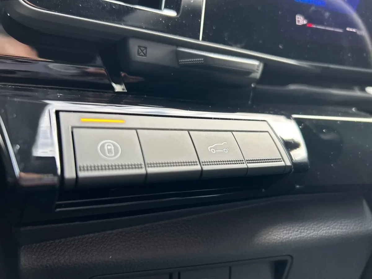 Gros plan sur les boutons de commande du tableau de bord noir du Renault Rafale esprit Alpine hybride 2025.