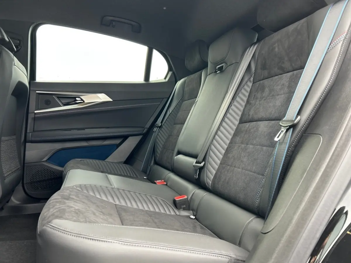 Vue intérieure côté droit des sièges arrière en cuir et alcantara noirs avec surpiqûres bleues du Renault Rafale 2025 esprit Alpine.