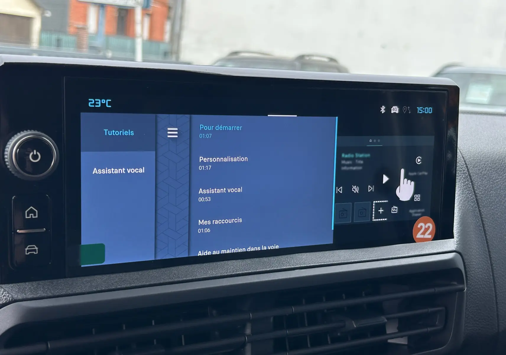 Écran tactile central du Citroën Jumpy Fourgon gris acier, affichant les tutoriels et assistant vocal, vue intérieure frontale.