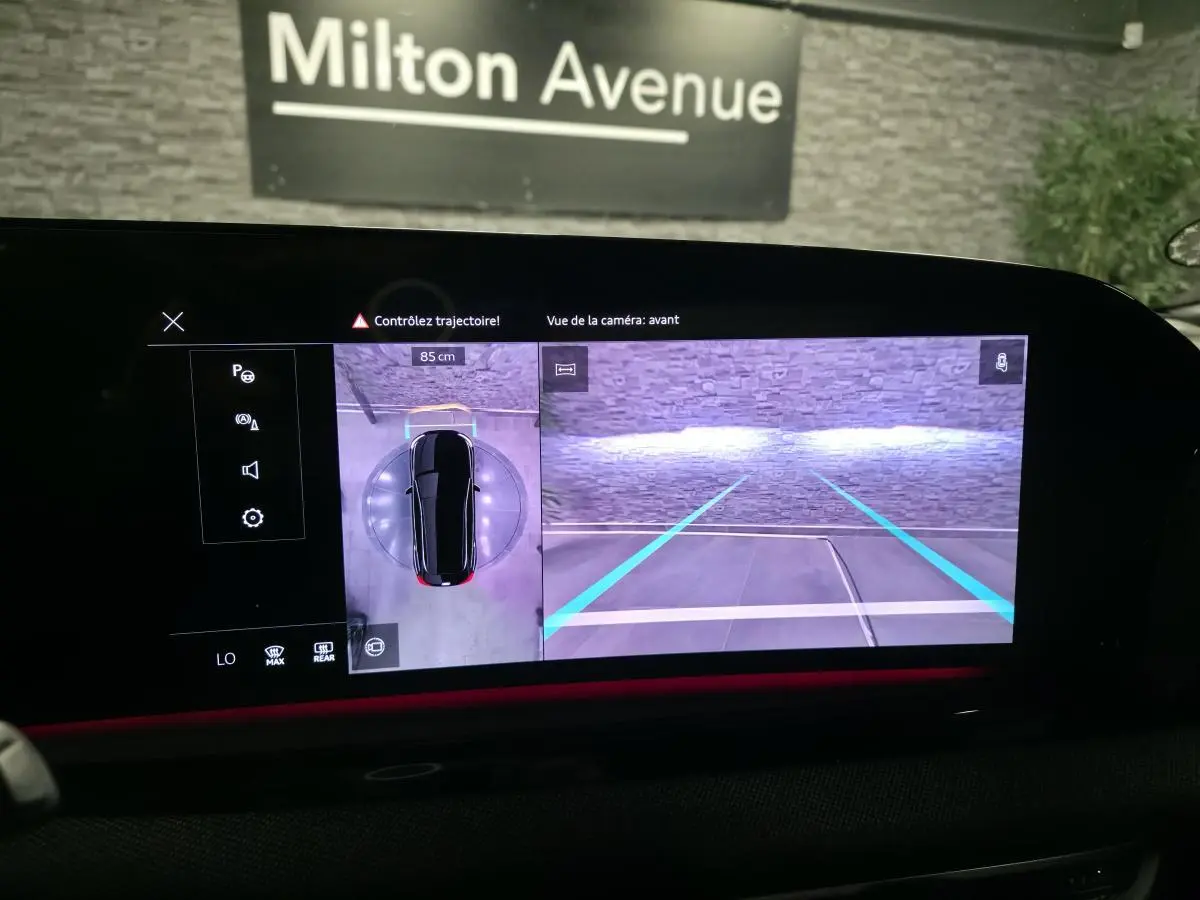 Écran MMI affichant la caméra avant et vue 360° d’une Audi A5 Avant noire en stationnement intérieur.