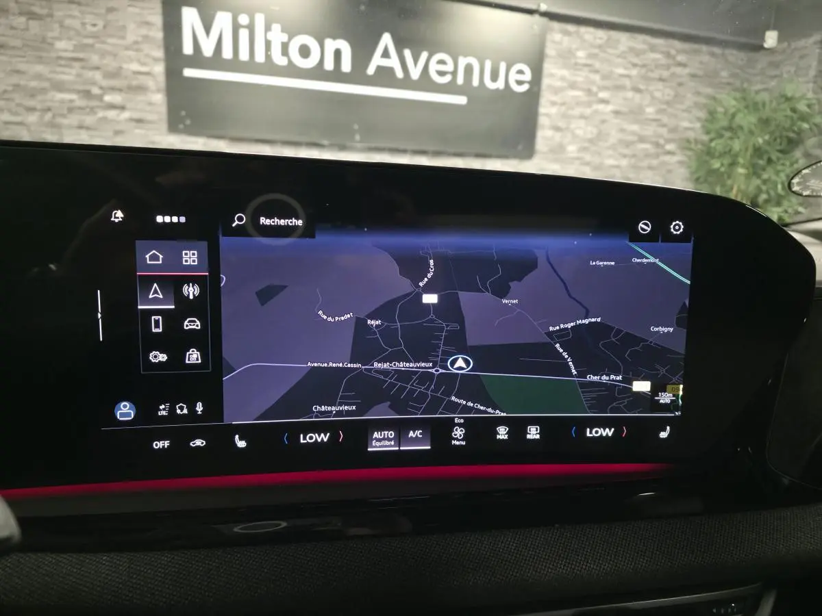 Vue rapprochée de l'écran MMI tactile de l'Audi A5 Avant noir, affichant la navigation et l'éclairage d'ambiance rouge.