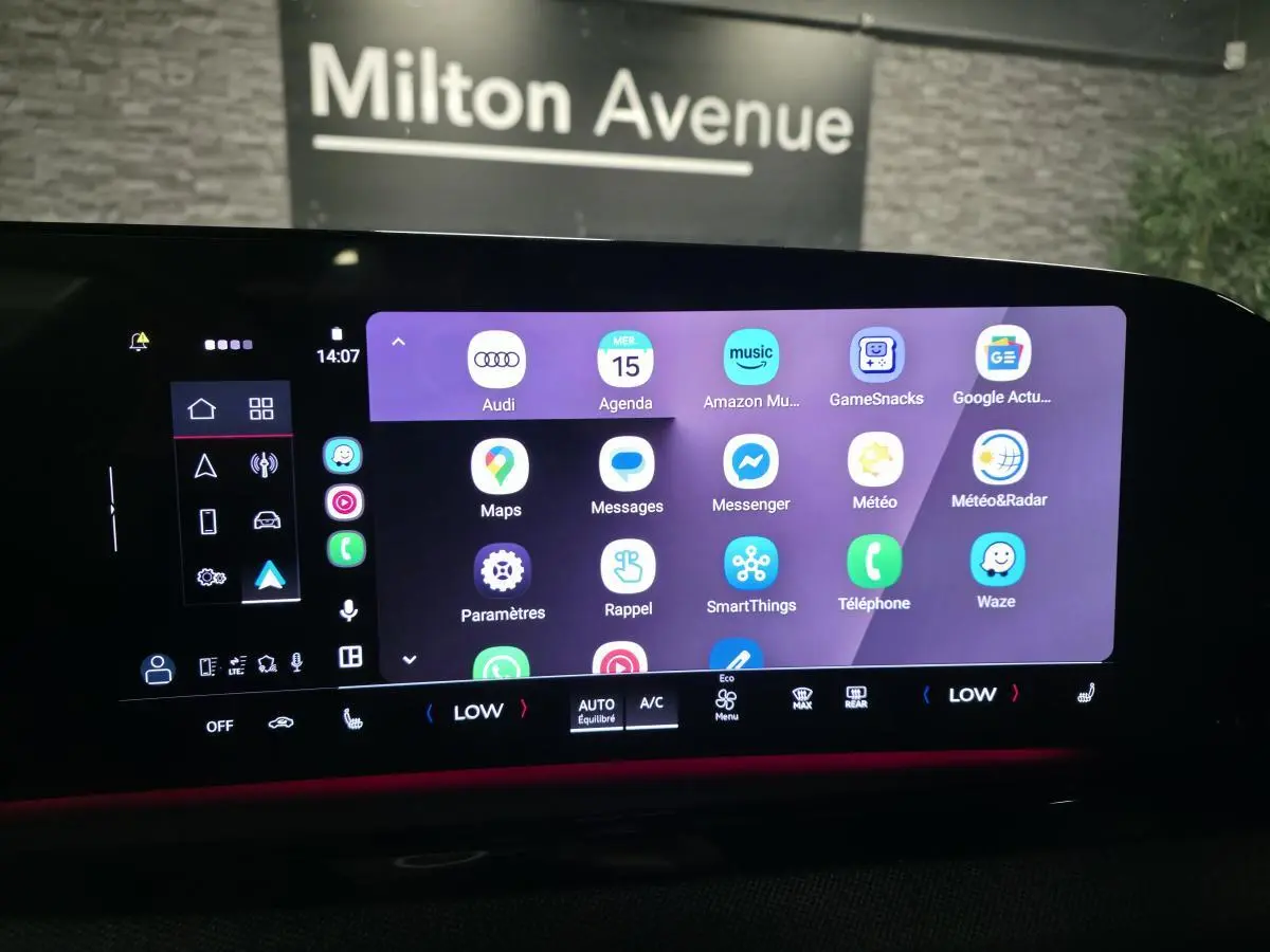 Écran tactile MMI large de l'Audi A5 Avant 2025 affichant des applications connectées avec éclairage d'ambiance rouge.