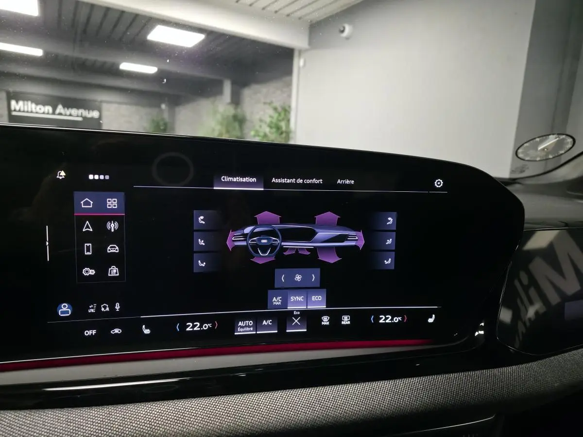 Écran tactile du système de climatisation de l'Audi A5 Avant noir, avec éclairage d'ambiance rouge visible.