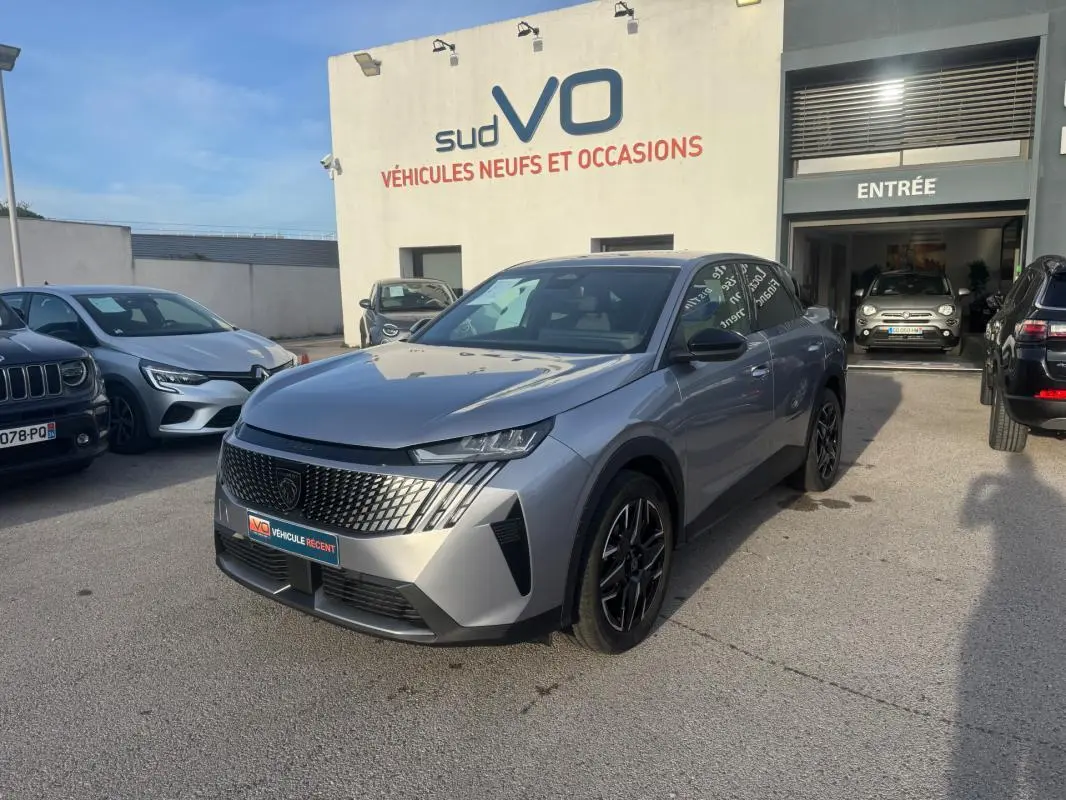 Peugeot 3008 Hybrid gris en 3/4 avant droit, avec calandre distinctive et jantes alliage noires 19 pouces.