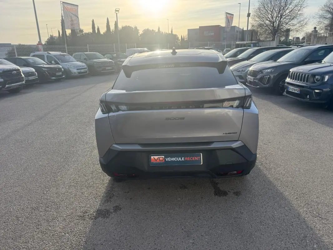 Vue arrière d’un Peugeot 3008 Hybrid gris 2025 avec feux arrière LED et badge Hybrid visible en concession.