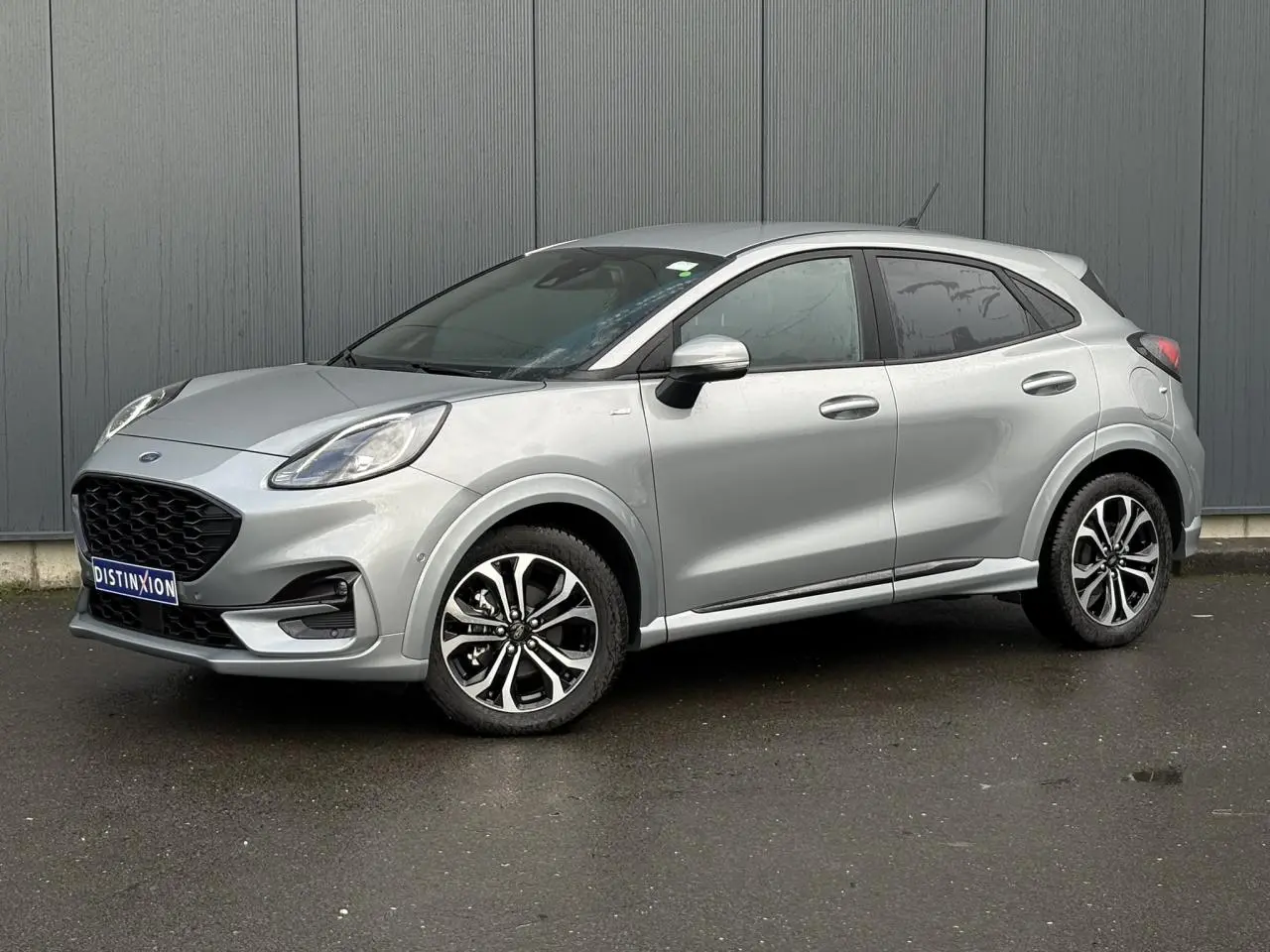 Ford Puma Ecoboost 155 ST Line gris Solar, vue 3/4 avant droit avec jantes alliage et vitres surteintées.