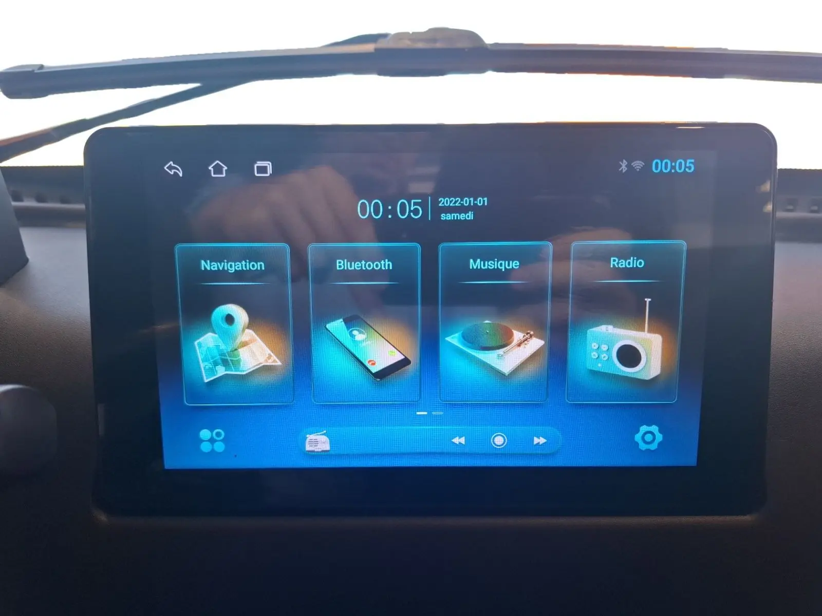 Écran tactile central du tableau de bord de la SIMPLICI S1 gris perle, affichant navigation, Bluetooth, musique et radio.
