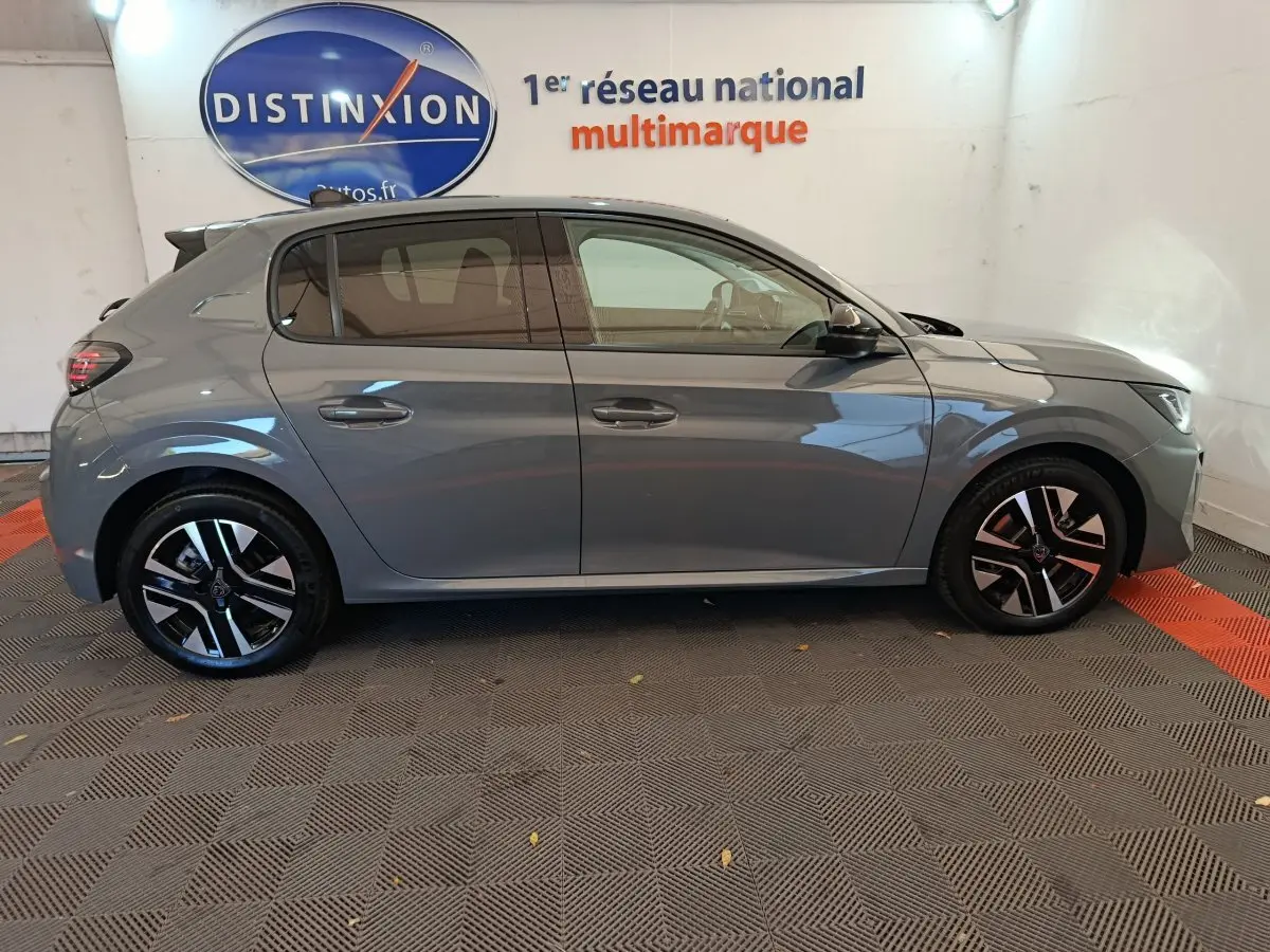 Profil côté droit d'une Peugeot 208 PureTech 100 S&S Allure gris foncé, avec jantes alliage et vitres teintées.