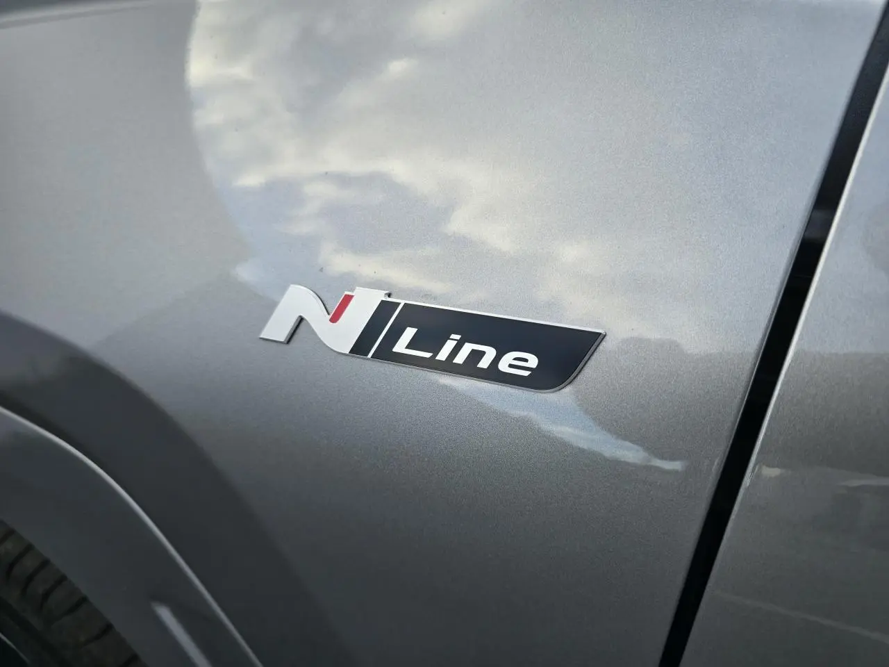 Gros plan sur l'emblème N Line sur la portière côté gauche d'un Hyundai Tucson 2025 couleur argent métallisé.