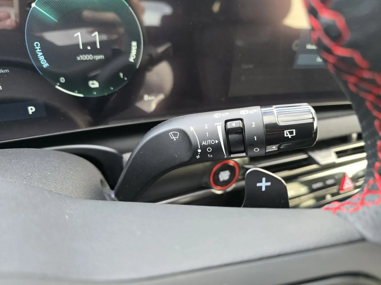 Gros plan sur la manette d’essuie-glace du Hyundai Tucson N Line 2025, volant cuir noir avec surpiqûres rouges visible.