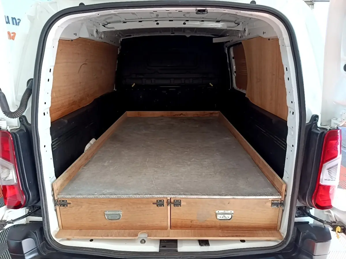 Vue arrière du Peugeot Partner blanc 2021 avec espace de chargement aménagé en bois et surface plane.