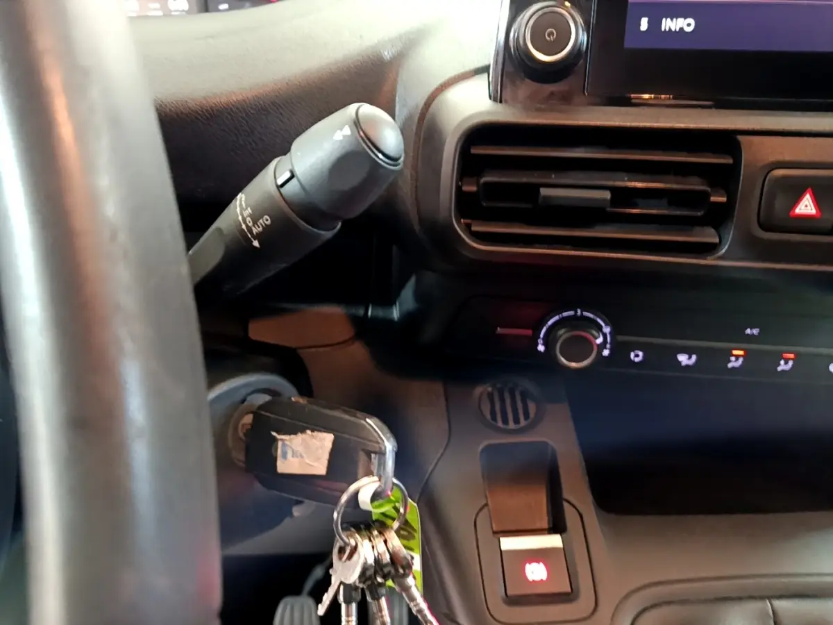 Gros plan sur le tableau de bord et volant noir du Peugeot Partner 2021 avec clé insérée dans le contacteur.