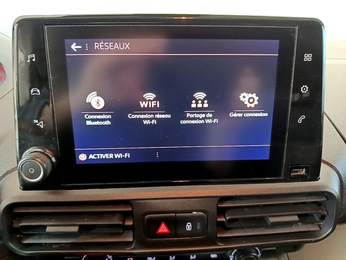 Écran tactile central du tableau de bord du Peugeot Partner 2021 affichant les options de connexion Wi-Fi et Bluetooth.