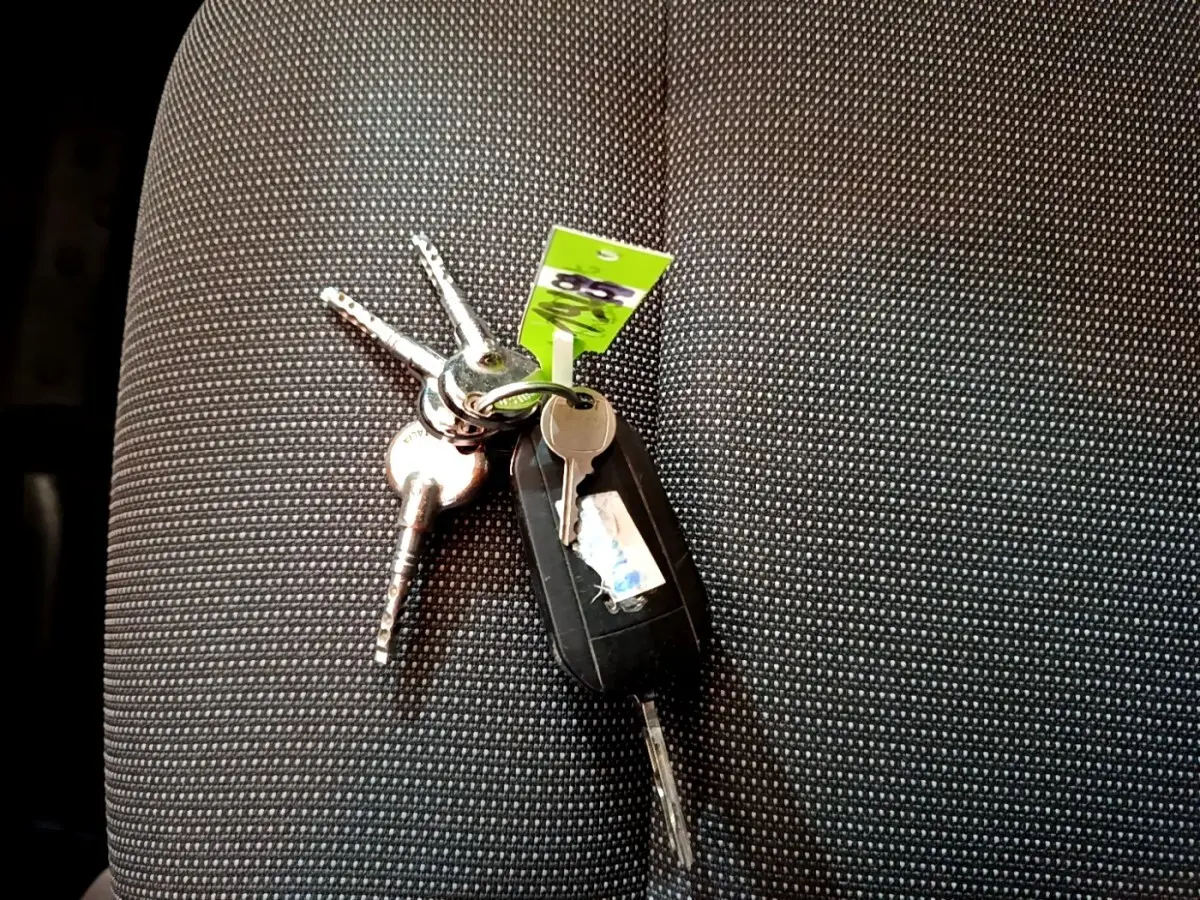 Je vois que l'image montre un jeu de clés posé sur un siège de voiture, mais elle ne montre pas le véhicule lui-même. Pourriez-vous fournir une image du véhicule pour que je puisse créer une balise alt conforme à vos instructions ?