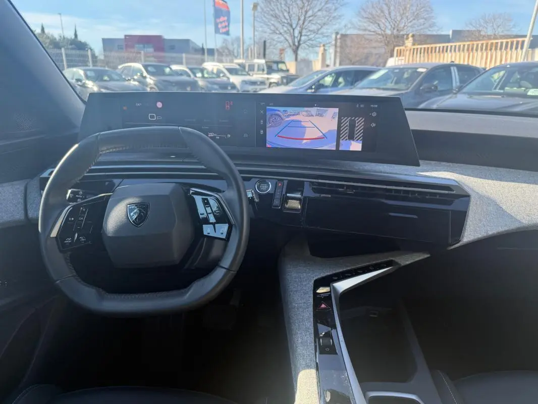 Vue intérieure du tableau de bord du Peugeot 3008 Hybrid 145 e-DCS6 Allure 2025, avec volant compact et écran numérique large.