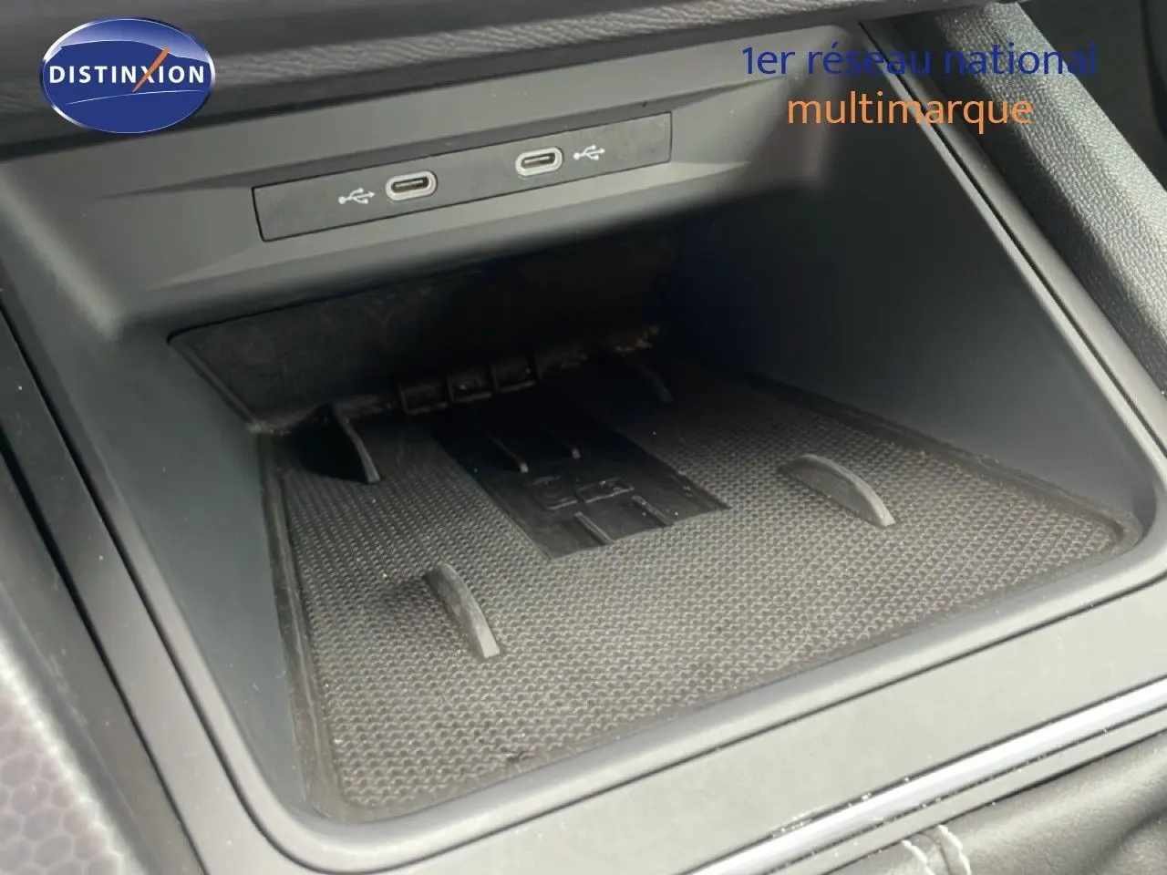 Gros plan sur la console centrale noire avec ports USB et espace de rangement du SEAT Leon blanc neige métal.