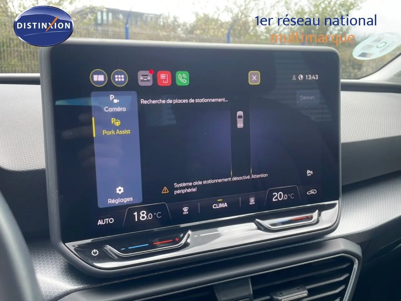 Écran tactile central affichant l'assistance au stationnement dans l'habitacle gris-noir d'une SEAT Leon blanche.