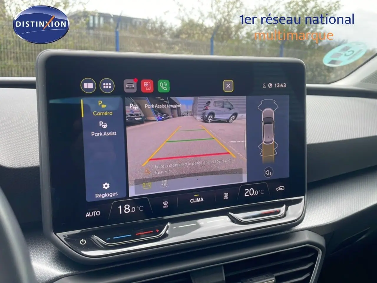 Écran tactile central affichant la caméra de recul et l'assistance au stationnement dans l'habitacle d'une SEAT Leon blanche.