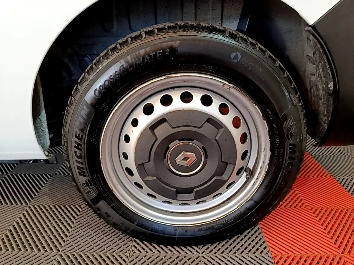 Gros plan sur la roue avant droite blanche d’un Renault Express 2021 avec jante acier et logo Renault central.