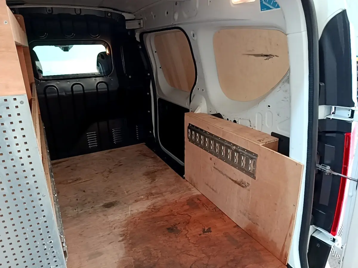 Vue intérieure arrière du Renault Express blanc 2021 avec cloison pleine et aménagements en bois.