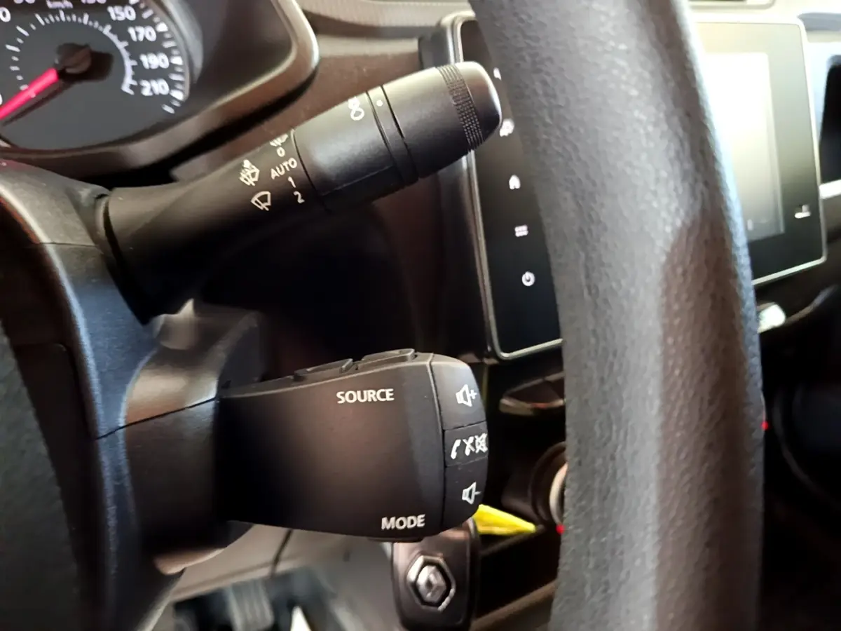 Gros plan sur la commande audio au volant noir du Renault Express 2021, avec tableau de bord et écran tactile visibles.