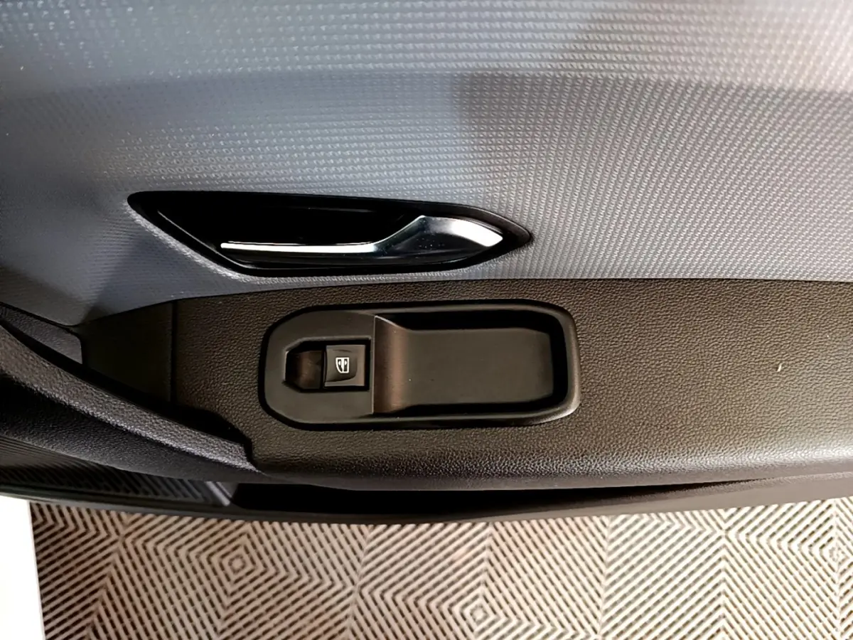 Gros plan sur la poignée intérieure et le bouton de lève-vitre côté conducteur du Renault Express Confort 2021.