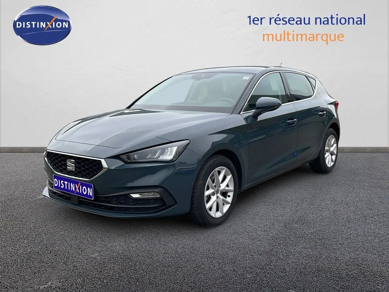 SEAT Leon 2.0 TDI 115CH STYLE XL bleu Fjord en 3/4 avant droit sur sol gris, calandre et phares LED visibles.