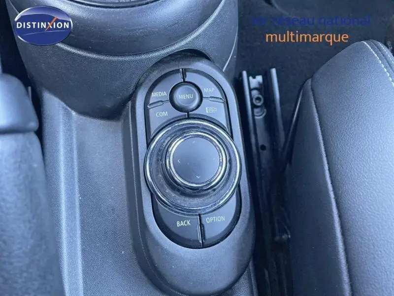 Gros plan sur la molette de commande centrale noire et les boutons environnants dans l’habitacle du MINI Cabriolet Midnight Black II.