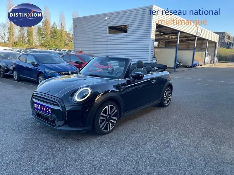 MINI Cabriolet Cooper 2023 noir Midnight Black II vue 3/4 avant avec capote ouverte sur parking extérieur.