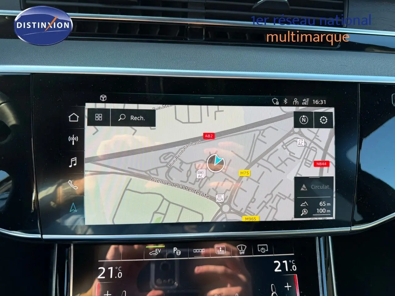Écran tactile central de l'Audi A8 noir Sebring 2024 affichant la navigation et la climatisation à 21°C