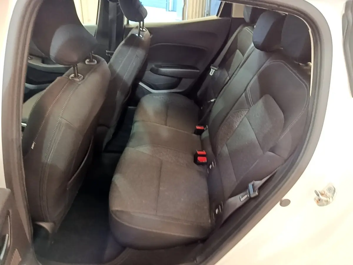 Vue intérieure côté droit montrant la banquette arrière noire et les sièges avant d'une Renault Clio blanche 2020.
