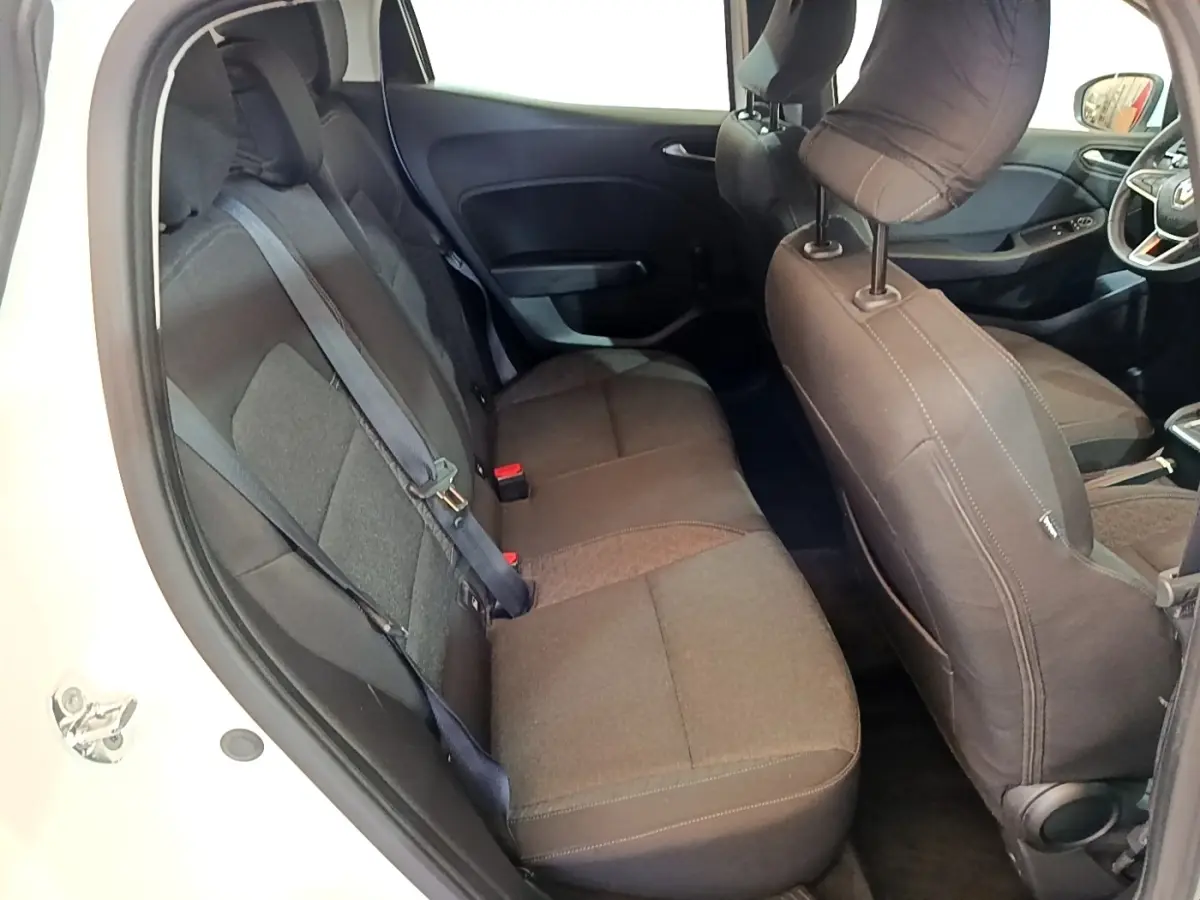 Vue intérieure côté gauche montrant la banquette arrière noire et les sièges avant d'une Renault Clio blanche de 2020.