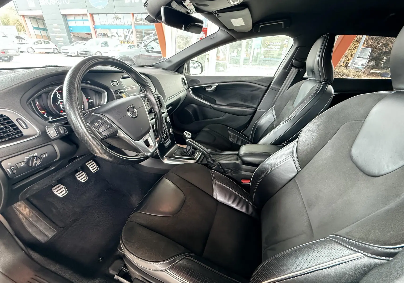 Intérieur noir cuir de la Volvo V40 R-Design 2017, vue côté conducteur avec volant multifonction et boîte manuelle.