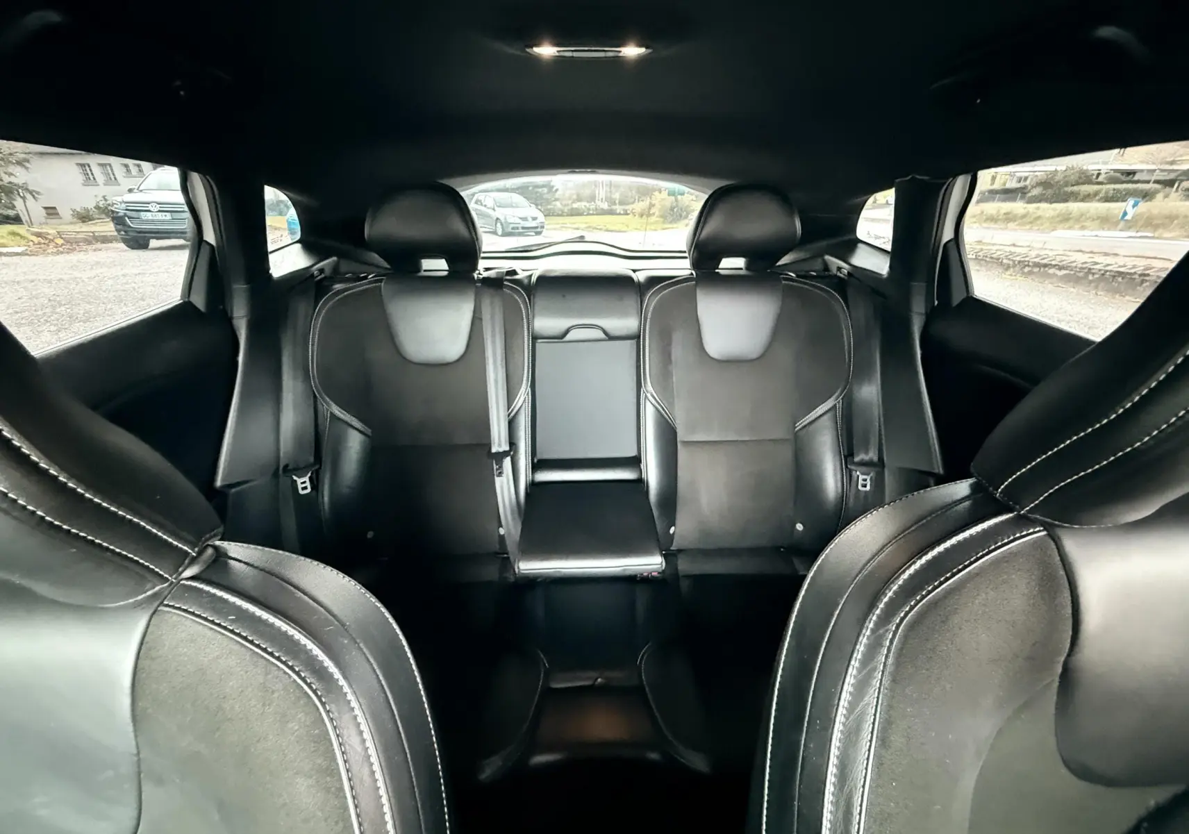 Vue intérieure arrière de la Volvo V40 R-Design 2017, sièges sport en cuir noir avec surpiqûres blanches.