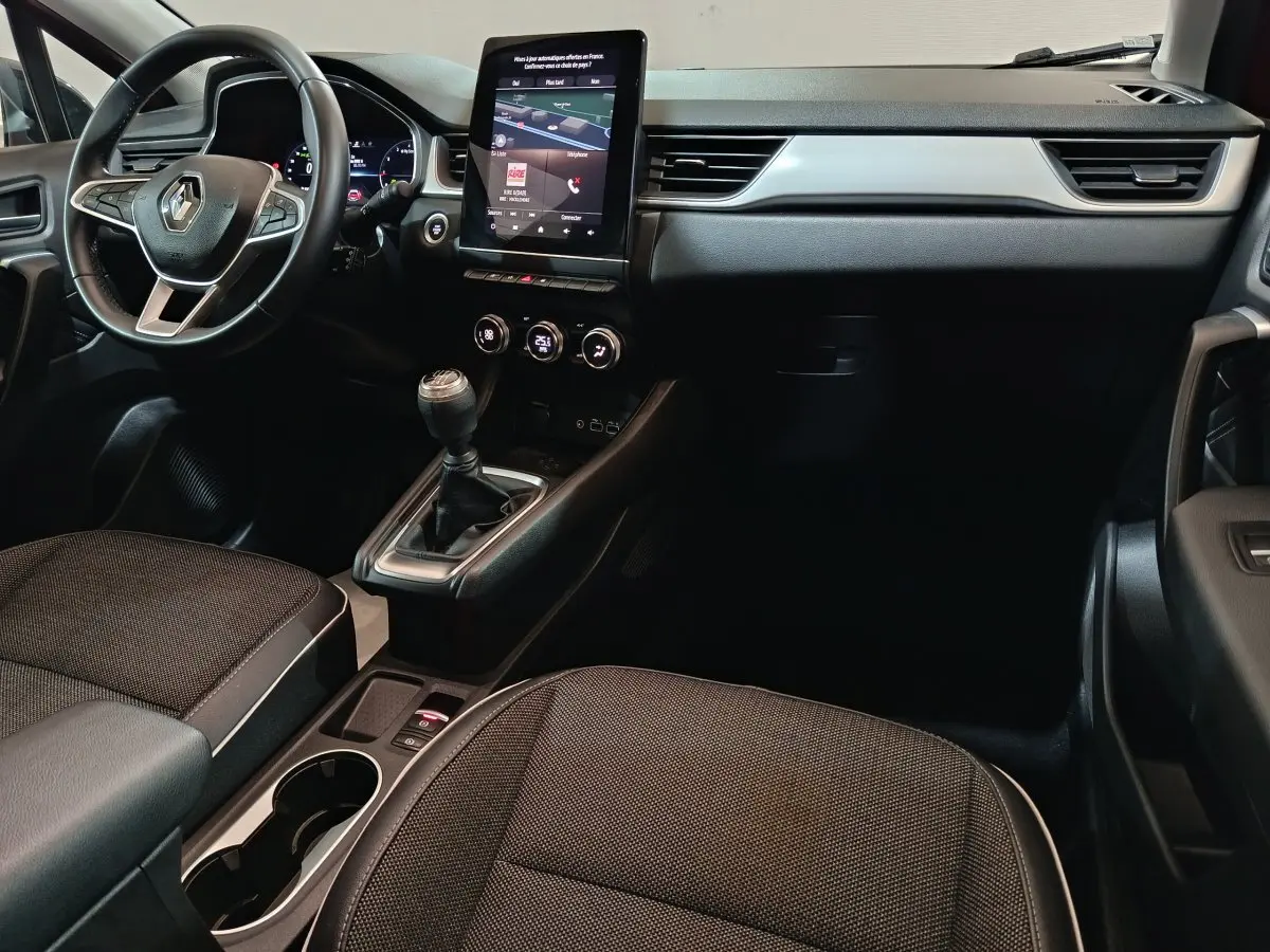 Intérieur du Renault Captur Techno TCe 90 2024, vue côté conducteur, tableau de bord noir avec écran tactile vertical.