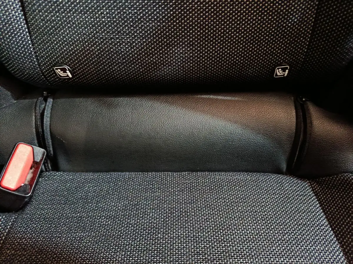 Gros plan sur la banquette arrière noire du Renault Captur 2024 avec fixation Isofix et boucle de ceinture rouge.