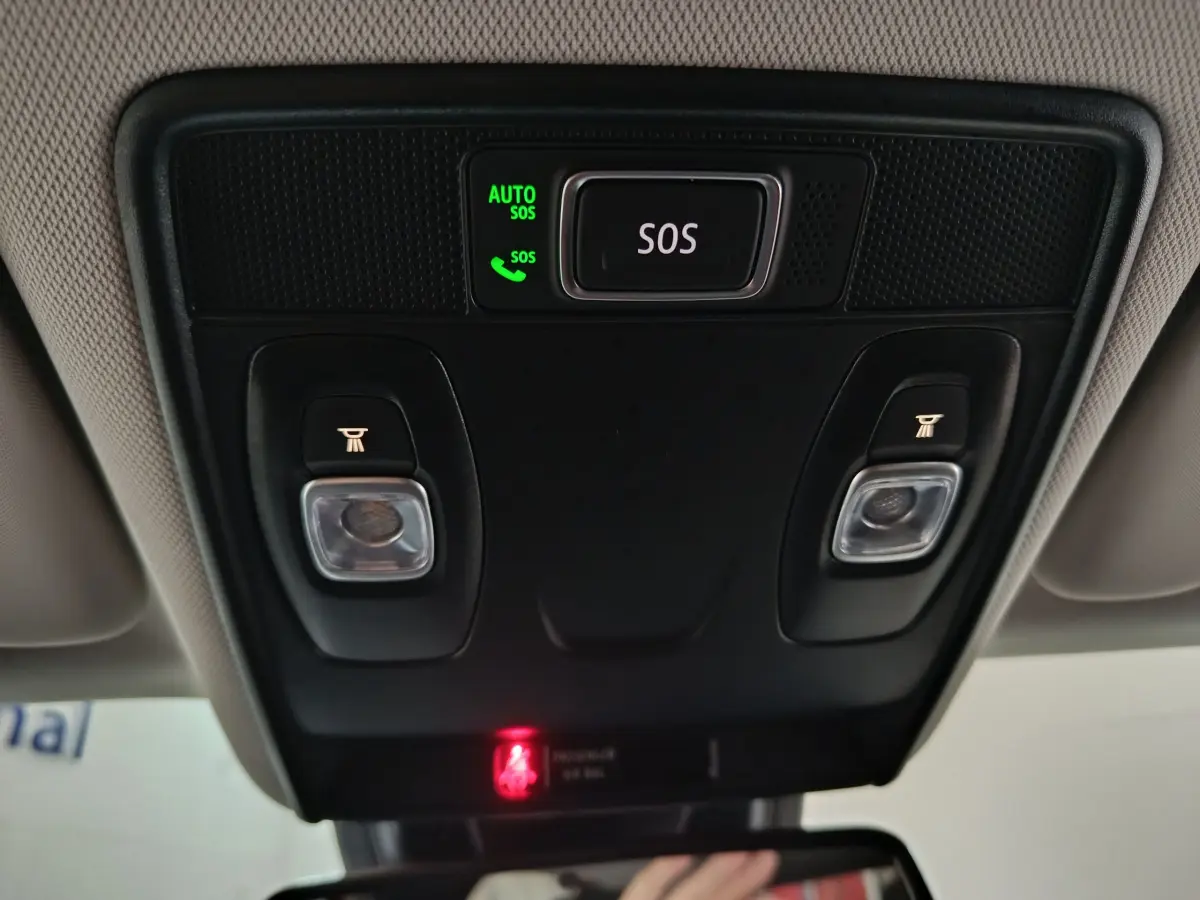 Gros plan sur la console de toit intérieure du Renault Captur rouge 2024 avec bouton SOS et éclairages intégrés.