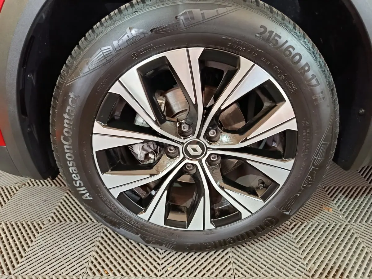 Gros plan sur la jante alliage noire et argentée du côté avant gauche du Renault Captur rouge 2024 Techno TCe 90